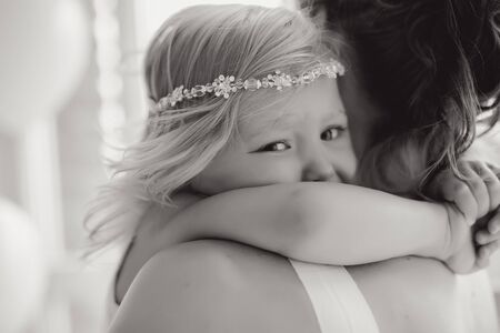 mother and daughter standing at the large window with the white balls in the Studioの写真素材