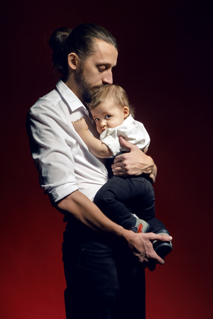 father and young son standing in Studio on red backgroundの写真素材