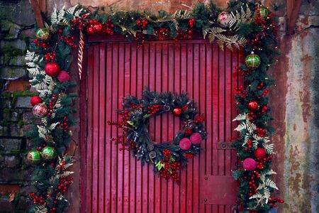 pine garland for Christmas hanging on red wooden wallの写真素材