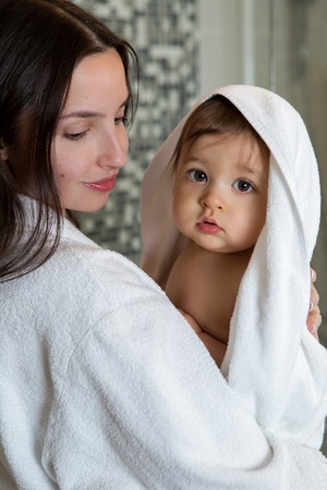 mother in a Bathrobe and with a child standing in the bathroomの写真素材