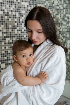 mother in a Bathrobe and with a child standing in the bathroomの写真素材
