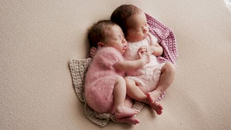 two girls twins newborn sleep in bedの写真素材