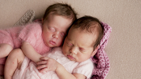 two girls twins newborn sleep in bedの写真素材