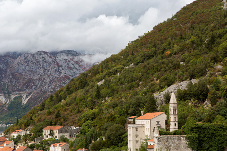Perast, Montenegro - September 12: roofs of old houses in Perast and Bay with mountains in...
