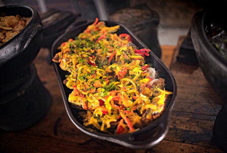 Moqueca. Brazilian seafood dish cooked in a clay pot on a wooden table. Traditional food found in...