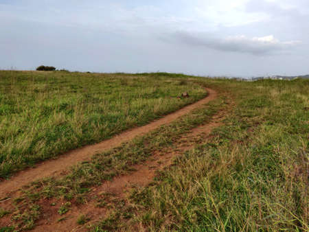 An old earthen road path running beyond the hills