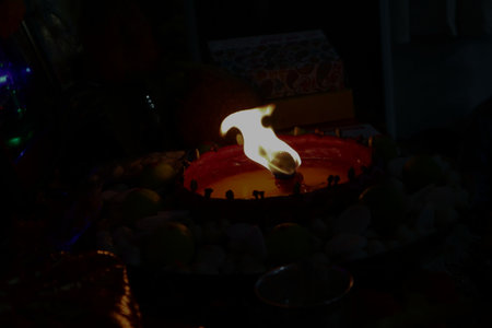Diya Flame in DarknessAn oil lamp burning with a strong flame in the dark, radiating spiritual energy during puja rituals.の写真素材