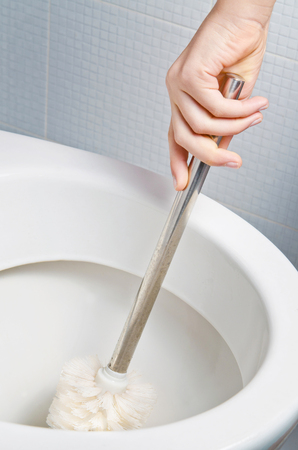 Closeup of hand brushing a toiletの写真素材
