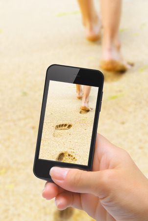 Hands taking photo beautiful woman legs with smartphoneの写真素材