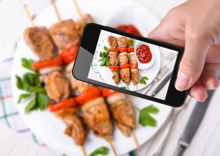 Hands taking photo kebab with smartphoneの写真素材
