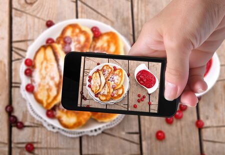 Hands taking photo pancakes with smartphoneの写真素材