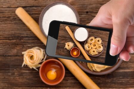 Hands taking photo pasta with smartphone.の写真素材