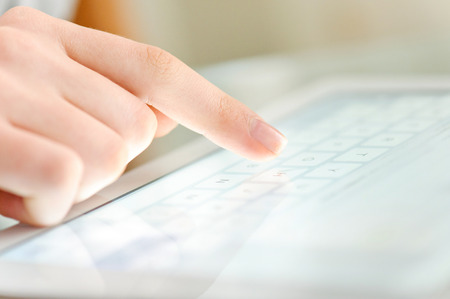 Hand touching screen on modern digital tablet pc.の写真素材