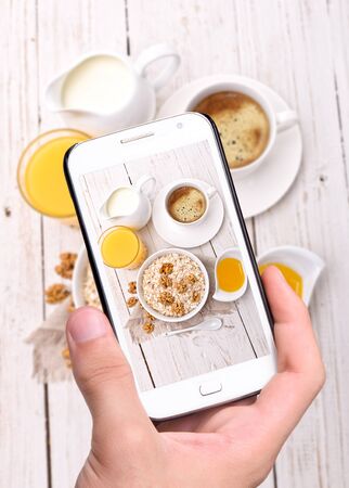 Hands taking photo breakfast with smartphoneの写真素材