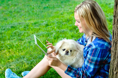 Girl using a digital tablet outdoorsの写真素材