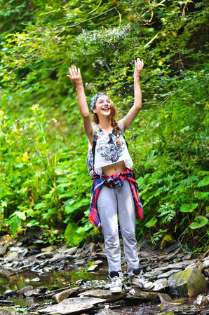 Young girl near stream water in mountain.の写真素材