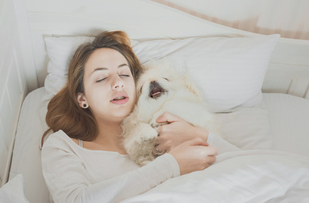 Girl and her dog in the bed.の写真素材