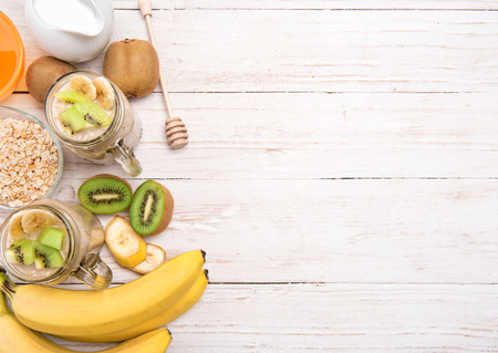 Smoothies with oatmeal, banana, kiwi in glass jars on a wooden background.Concept of cooking.の写真素材
