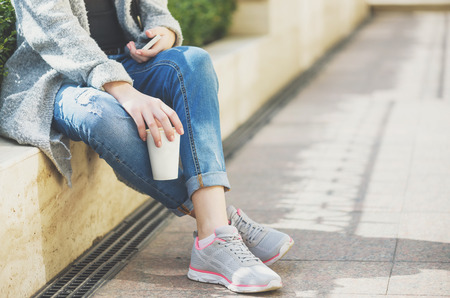 Girl using a cell phone outdoors.の写真素材