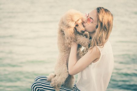 Young girl is resting with a dog on the sea.の写真素材