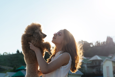 Young girl is resting with a dog on the outdoors.の写真素材
