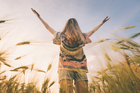 Beautiful girl on the field in sun light.の写真素材