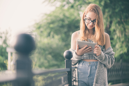 Girl using a digital tablet outdoors. Toning.の写真素材