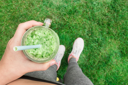 Young girl drinking fruit smoothie. Fitness and healthy lifestyle concept.