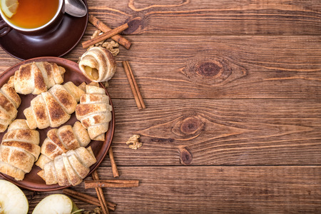 Fresh homemade croissants with apple and cup of tea.の写真素材