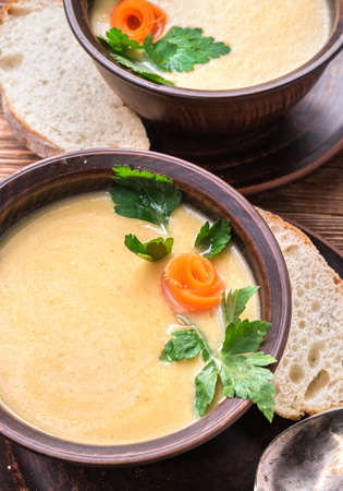 Pea soup in the bowl on a rustic wooden background.の写真素材