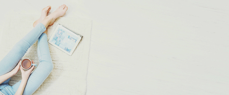 Young women are resting on the floor at home and using a tablet.の写真素材