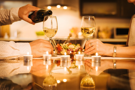 Wine is poured into a glass. Romantic concept.の写真素材