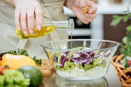 Pouring olive oil on freshly made salad.の写真素材