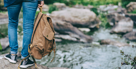 Woman traveler with backpack. Background of natural canyon with view of the mountain river. Concept...