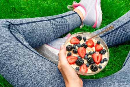 Young girl eating a workout with berries after a workout.の写真素材