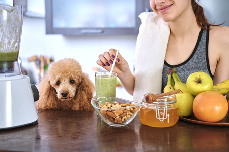 Woman drinking smoothie in home kitchen after a workout.の写真素材
