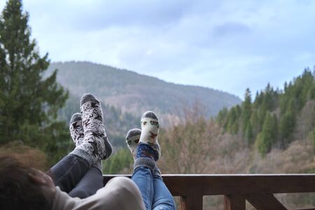 The young couple's feet laid on the wooden railing.の写真素材