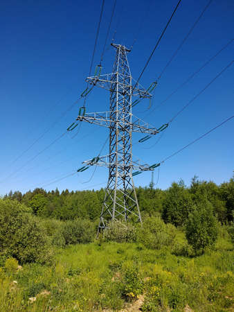 High voltage power transmission tower. Clearing in the forest.