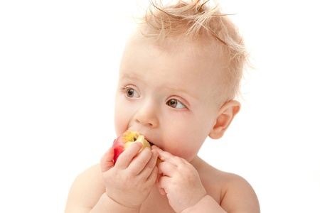 baby eating red apple, isolatedの写真素材