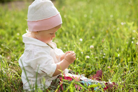 baby girl sitting on grassの写真素材