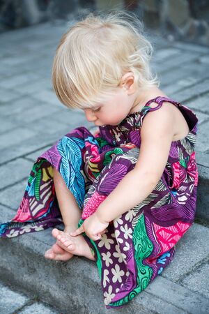 little girl sitting on stairsの写真素材