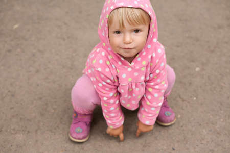 little girl sitting on the ground