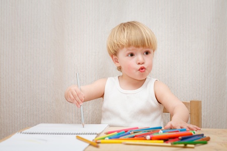 little girl sitting at the desk  drawing indoorsの写真素材