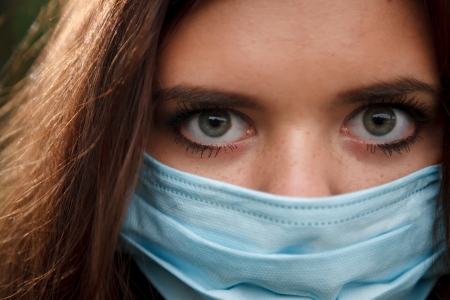 macro of young female in mask looking at camera