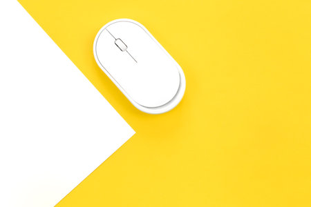 Computer mouse on a yellow background close-up, top view.の写真素材