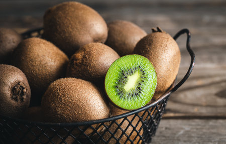 Close-up, whole kiwi and half in a basket.の写真素材