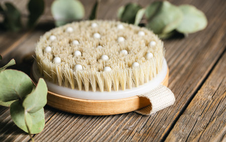 Dry massage brush close-up on a wooden background.