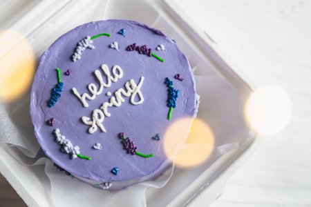 Delicious bento cake Hello spring on white wooden background, copy space.