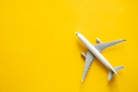 Airplane model on yellow background isolated, flat lay.の写真素材