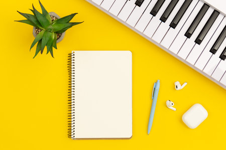 Piano and notebook on yellow background, flat lay, copy space.の写真素材